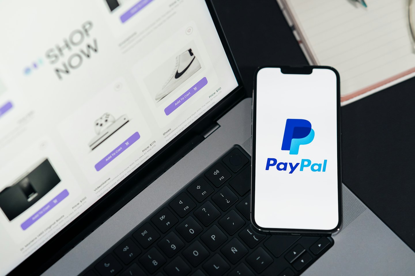 Un smartphone con un logo de pago descansa sobre el teclado de un portátil.